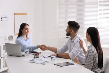 Real estate agent shaking hands with client in office. Mortgage concept