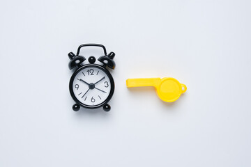 A picture of alarm clock and whistle on white background. Extra time concept