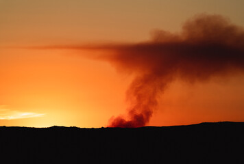 Fire over the horizon at sunset silhouette