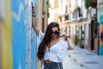 Young and pretty girl with sunglasses in different places in the city.
Fashion and beauty concept, urban photography.