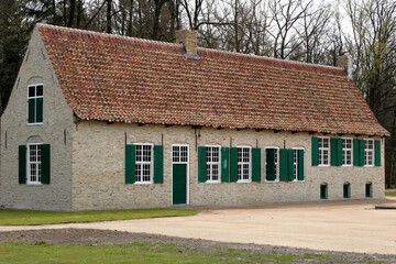 Fototapeta na wymiar old farmhouse with green windows in a rural landscape