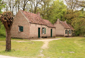 Fototapeta na wymiar old stone farmhouse with green windows in a rural landscape