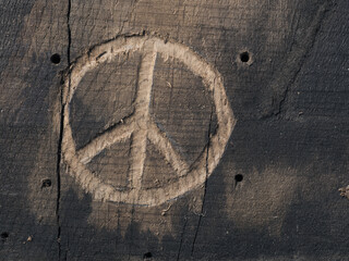 The peace symbol carved in wood with chisels. Peace concept