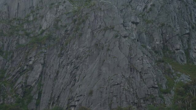 Huge granite wall from the botom to the top on a cloudy day.