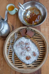  Chinese New Year festive snacks. Coconut Rolled Steamed Nian Gao Balls. Also called new year cake, steamed till soft, use a fork and spoon to crape a piece and rolled with fresh grated young coconut © ysk1