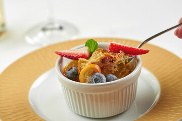 Dessert creme brulee in a plate on a white tablecloth. Close-up