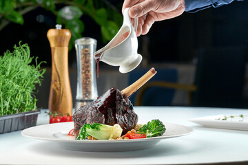 Baked lamb shank is poured with sauce composed with spices. © ismishko