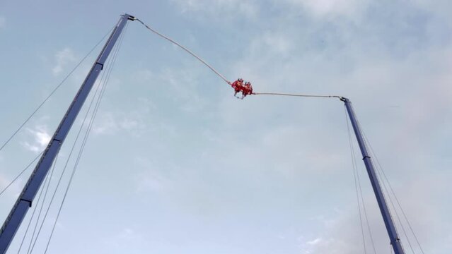 Extreme flying dangerous attraction. Jumping on rubber ropes. Extreme types of recreation and entertainment. A large catapult that shoots brave men.