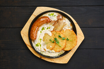 Overhead view of potato fritters with with fried sausage and pork belly