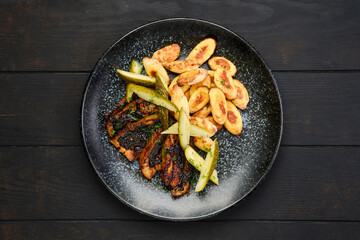 Overhead view of roasted pork belly slices with gnocchi