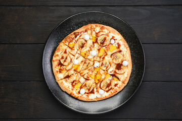 Overhead view of sweet pie with banana, orange, cranberry and caramel syrup