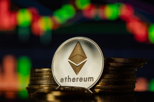Stack or heap of silver Ethereum cryptocurrency with candle stick graph chart and digital background, in Bucharest, Romania, on March 15, 2022.