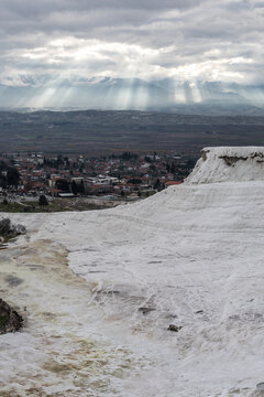 Sun light piercing through the clouds and hitting the mountains