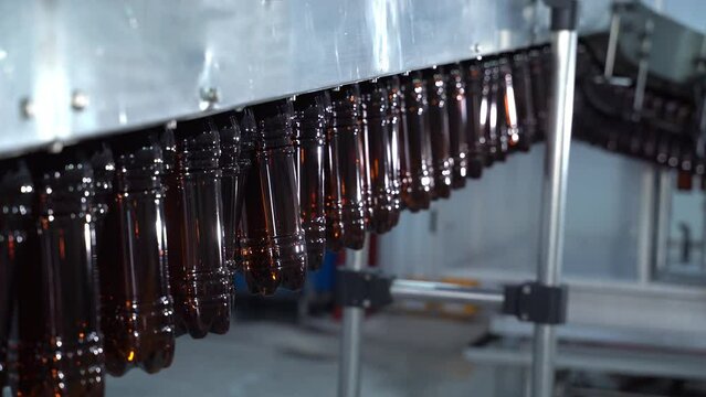 Light Beer Bottling Plant Belt At Beer Factory. Empty plastic bottles are moving in the conveyur. Alcohol factory. Business concept