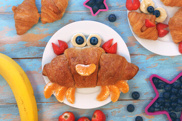 Fun idea for kids breakfast. Cute crab croissant with berries and fruits. Fun food for children.