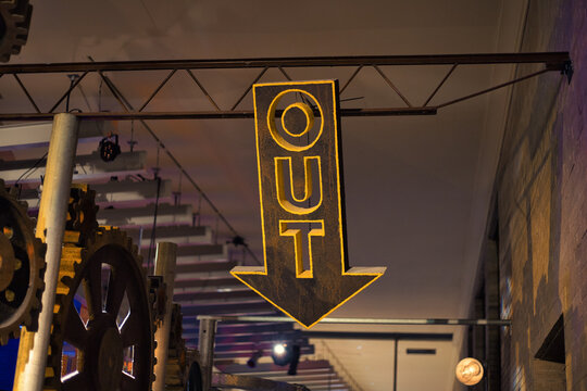 Selective of a hanging sign informing about the exit in the evening