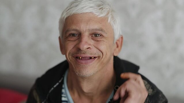 Funny toothless smiling man at home