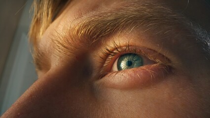Detail shot of human blue eye. Young man working on computer. Concentrated look. © Big Shot Theory