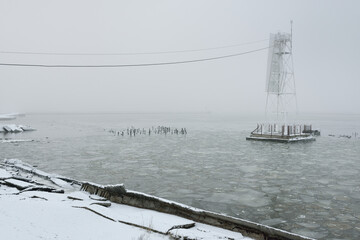 Frozen river, pier, embankment, city park. Snow, thick fog. Concept winter urban landscape. Architecture, logistics, infrastructure themes - 494414164