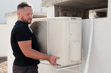 the worker installing and connecting a new air conditioner unit
