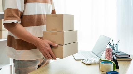Online shopping concept the seller holding three boxes of his products to post them