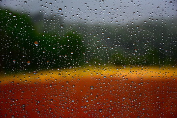 rain drops on a glass and yellow red and green background
