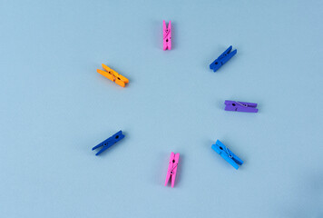 multicolored clothespins on a blue background, copy space, close-up
