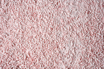 Texture of pink grains top view. Pink grain background. Drip pattern. The texture of pink gravel. Pink pebbles close-up..