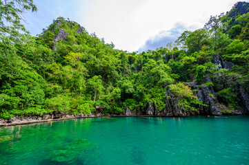 Kayangan Lake - Blue crystal water in paradise lagoon - walkway on wooden pier in tropical scenery - Coron island, Palawan, Philippines. - obrazy, fototapety, plakaty
