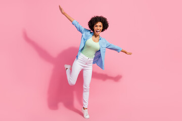 Photo of cheerful carefree inspired lady stay leg plane pose make wings wear denim shirt isolated...