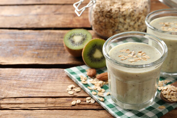 Tasty kiwi smoothie with oatmeal on wooden table, space for text