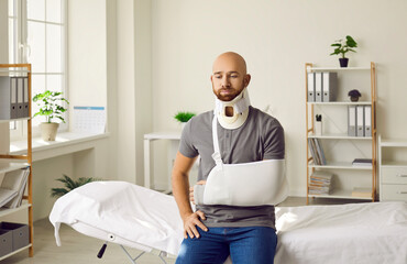 Sad man with broken arm in sling and with fixing collar around his neck sitting in hospital....