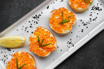 Bruschetta with red caviar, with lemon and green onions