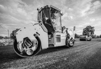 Vibratory asphalt rollers compactor compacting new asphalt pavement. Road service repairs the...