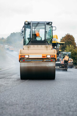 Vibratory asphalt rollers compactor compacting new asphalt pavement. Road service repairs the highway	
