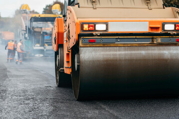 Vibratory asphalt rollers compactor compacting new asphalt pavement. Road service repairs the highway	
