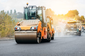 Vibratory asphalt rollers compactor compacting new asphalt pavement. Road service repairs the highway	
