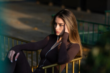 Portrait of a fashionable young brunette woman wearing solid long sleeve bodycon one piece jumpsuits