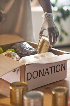 Unrecognizable African American Man Wearing Protective Latex Gloves Packing Food Supplies Into Donation Box