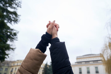 Two caucasian women holding hands and looking up
