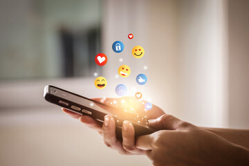 Young man using smartphone sending emojis. Mobile smartphone sending text messages emoji emoticon. - 494423571