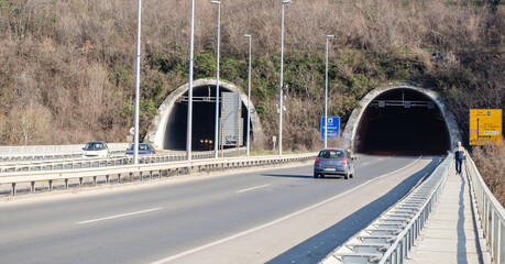 Tunnel on the end of the Liberty bridge with cars and road signs under the part of Fruska gora...