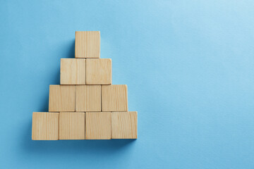 Blank wooden cubes on light blue background, flat lay. Space for text