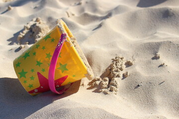 Colorful sand bucket to play at the beach on a sunny day in vacation time 