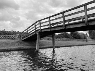 an old wooden bridge over the river in black and white