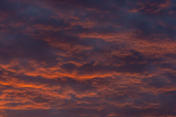 Naklejka na ściany i meble Colorful clouds in the rays of the setting sun