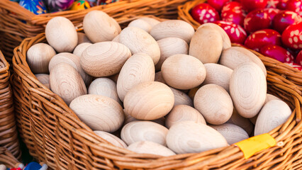 A basket of wooden Easter eggs for self-coloring on the counter of the Easter market in Krakow. Traditional symbols of Easter. Selective Focus