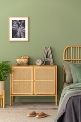 Stylish composition of modern bedroom interior. Mock up poster frame, rattan commode, beautiful...