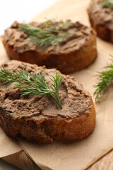 Slices of bread with delicious pate and dill on wooden board, closeup