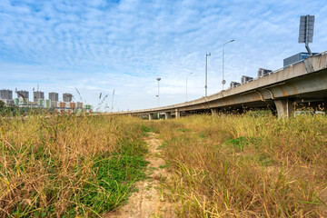 Fototapeta premium Concrete structure and asphalt road space under the overpass in the city
